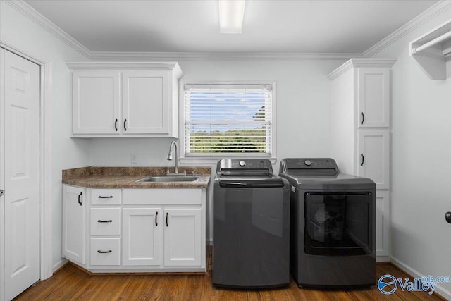laundry room featuring crown molding, separate washer and dryer, a sink, and cabinet space