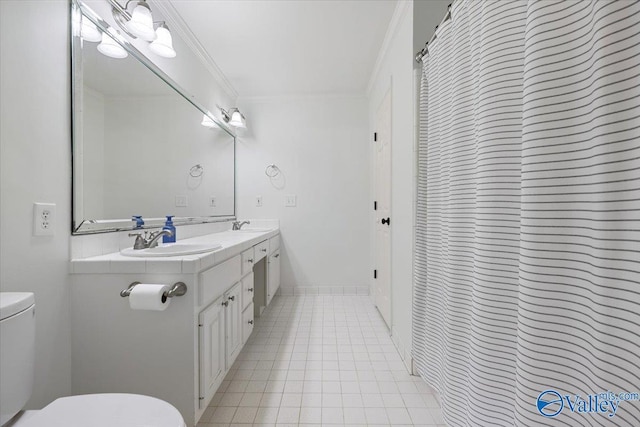 bathroom featuring double vanity, a sink, toilet, and ornamental molding