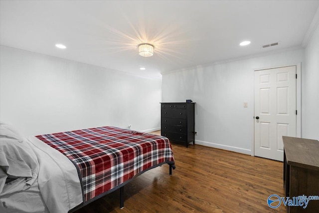 bedroom featuring visible vents, crown molding, wood finished floors, baseboards, and recessed lighting