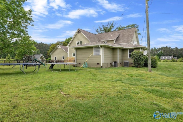 view of property exterior featuring central air condition unit, a trampoline, a lawn, and crawl space