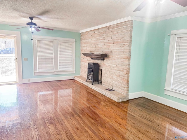 unfurnished living room featuring crown molding, ceiling fan, hardwood / wood-style flooring, and a textured ceiling