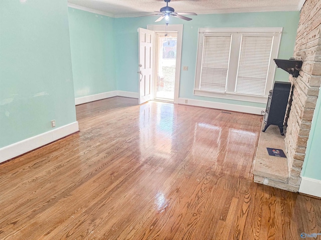 unfurnished living room with ornamental molding, wood-type flooring, a textured ceiling, and ceiling fan