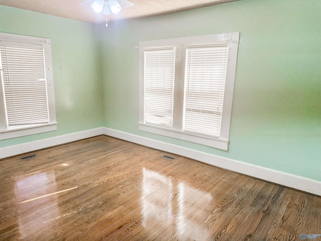 empty room with ceiling fan and wood-type flooring