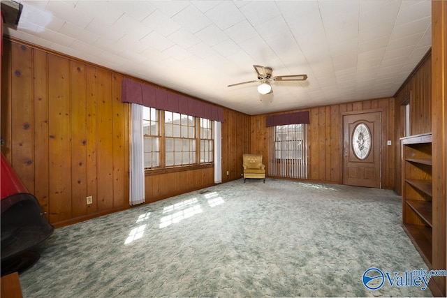 514 W St, Scottsboro, AL 35768 - unfurnished living room featuring carpet, wooden walls, and ceiling fan