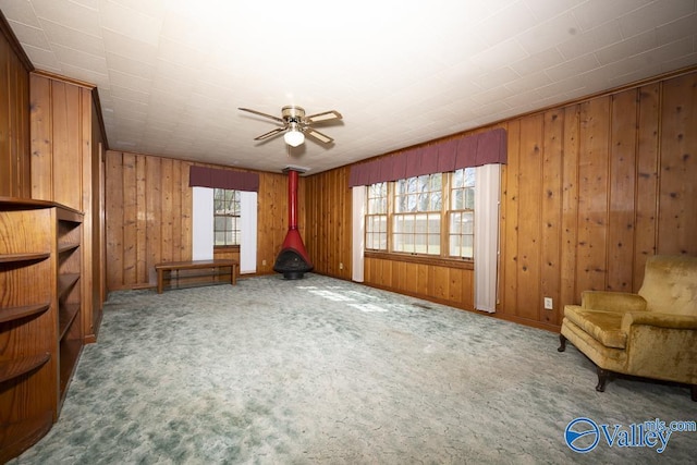 514 W St, Scottsboro, AL 35768 - unfurnished living room featuring carpet flooring, a ceiling fan, and wood walls