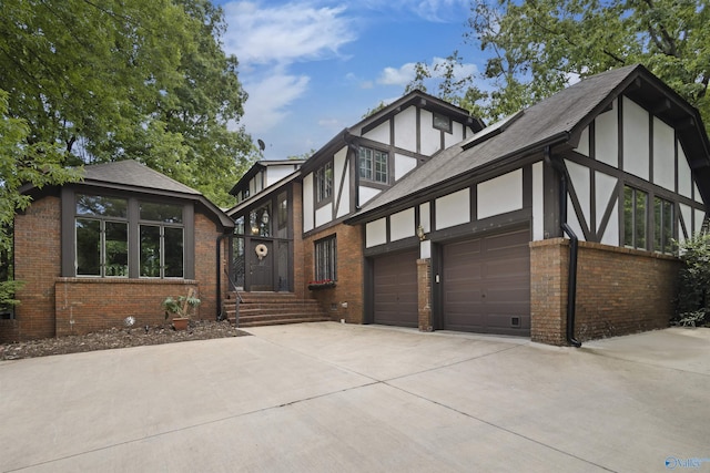 view of front of house with brick siding, driveway, stucco siding, and roof with shingles