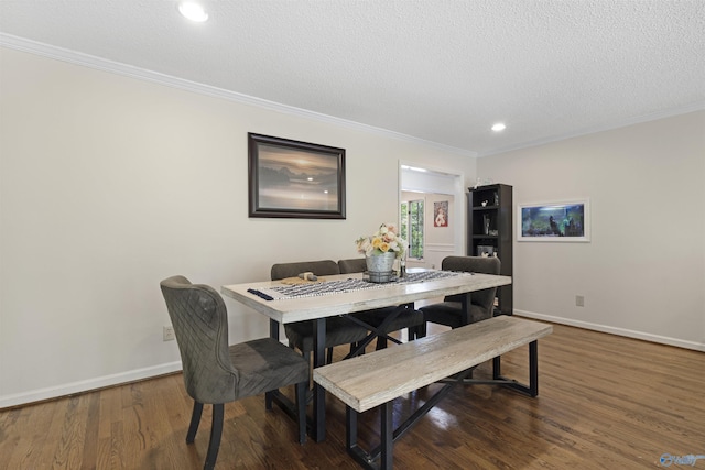 dining area featuring wood finished floors, crown molding, baseboards, a textured ceiling, and recessed lighting