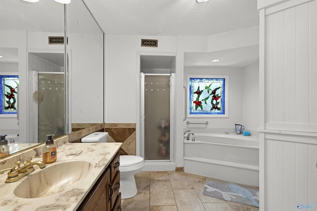 full bath featuring a stall shower, vanity, a textured ceiling, a garden tub, and tile patterned flooring