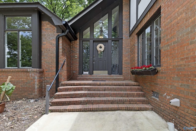 view of exterior entry with brick siding
