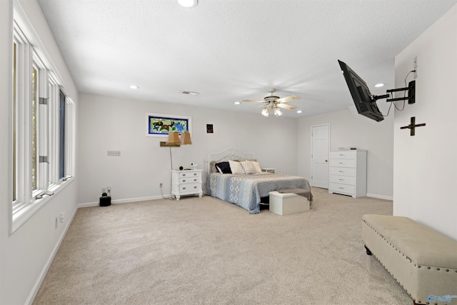 bedroom with multiple windows, recessed lighting, baseboards, light colored carpet, and a textured ceiling