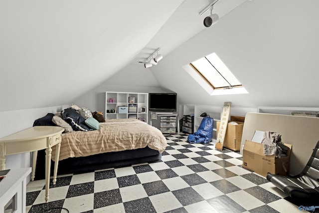 bedroom featuring track lighting, tile patterned floors, vaulted ceiling, and a skylight