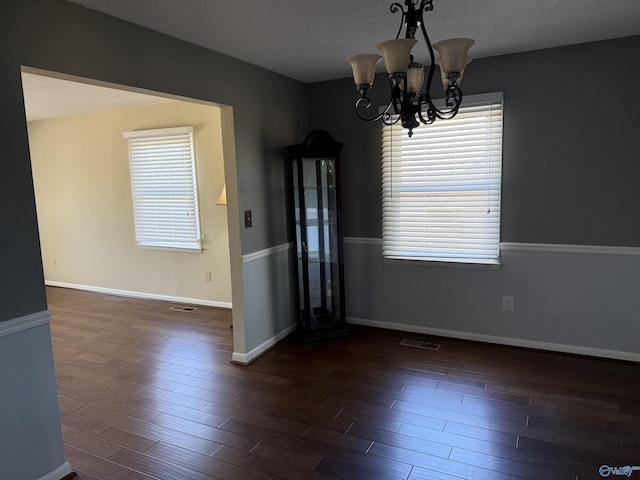 1903 Garner St, Scottsboro, AL 35769 - unfurnished dining area featuring visible vents, baseboards, an inviting chandelier, and wood finished floors