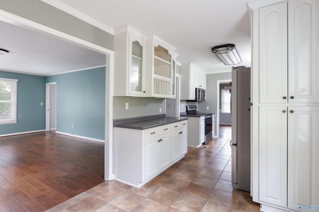 1903 Garner St, Scottsboro, AL 35769 - kitchen featuring ornamental molding, glass insert cabinets, dark countertops, white cabinets, and stainless steel appliances