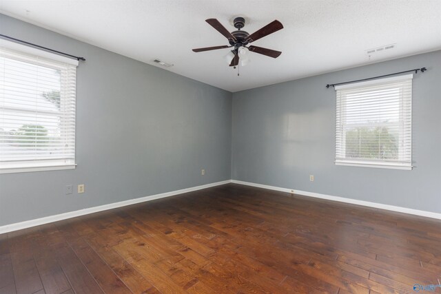 1903 Garner St, Scottsboro, AL 35769 - empty room featuring visible vents, dark wood-style flooring, and a healthy amount of sunlight