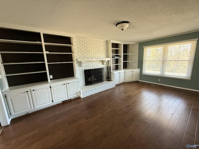1903 Garner St, Scottsboro, AL 35769 - unfurnished living room with a fireplace, a textured ceiling, visible vents, dark wood-style flooring, and baseboards