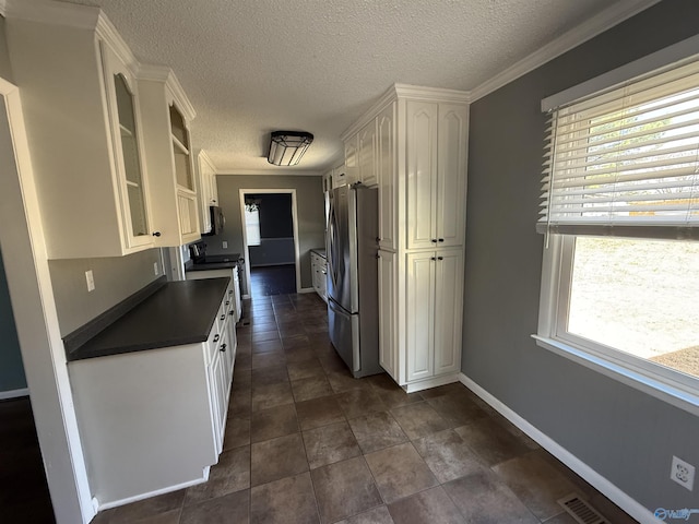 1903 Garner St, Scottsboro, AL 35769 - kitchen featuring glass insert cabinets, white cabinetry, visible vents, appliances with stainless steel finishes, and dark countertops