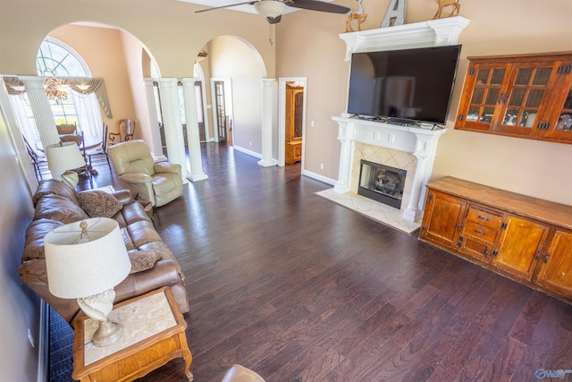 living room featuring wood-type flooring, ceiling fan, and a tiled fireplace