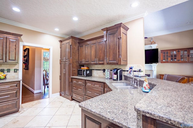 kitchen featuring ornamental molding, sink, tasteful backsplash, and light wood-type flooring