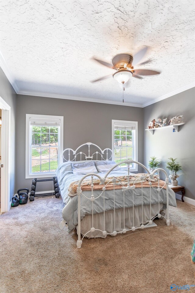 carpeted bedroom with ceiling fan and ornamental molding