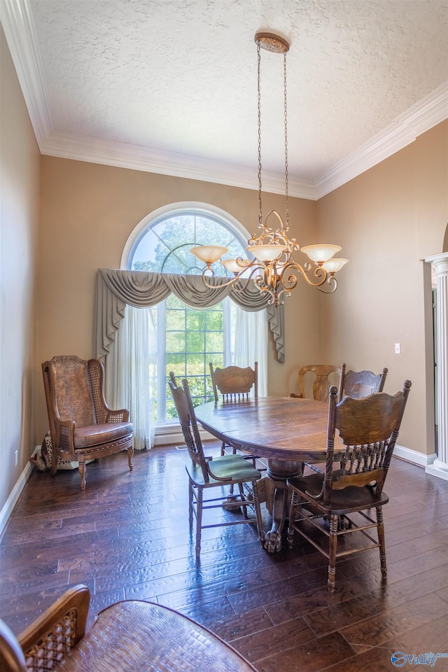 dining space with a textured ceiling, wood-type flooring, crown molding, and a chandelier