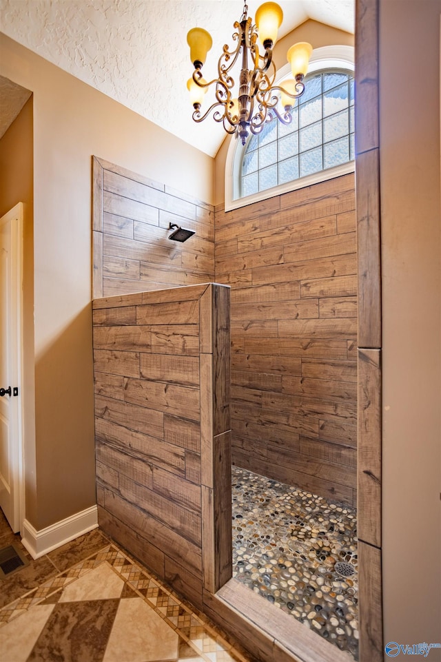 bathroom with lofted ceiling, tile patterned flooring, walk in shower, and a chandelier