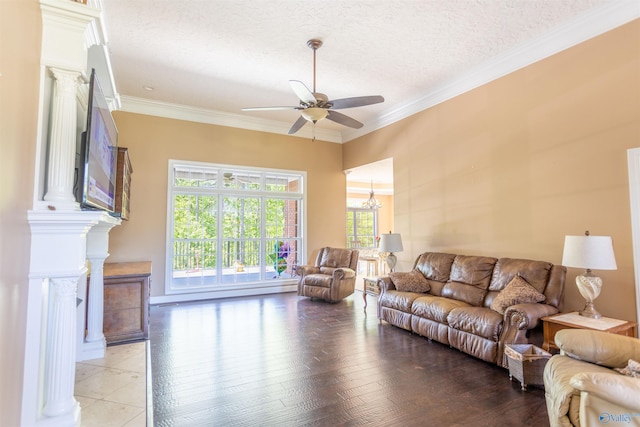 living room with ceiling fan with notable chandelier, light wood-type flooring, ornamental molding, decorative columns, and a textured ceiling