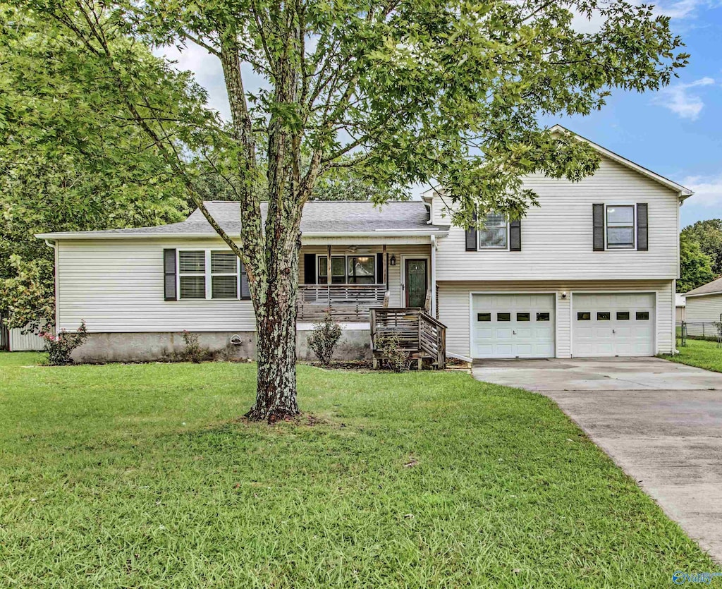 split level home featuring a front lawn, a porch, and a garage