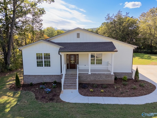 ranch-style home with a porch and a front lawn