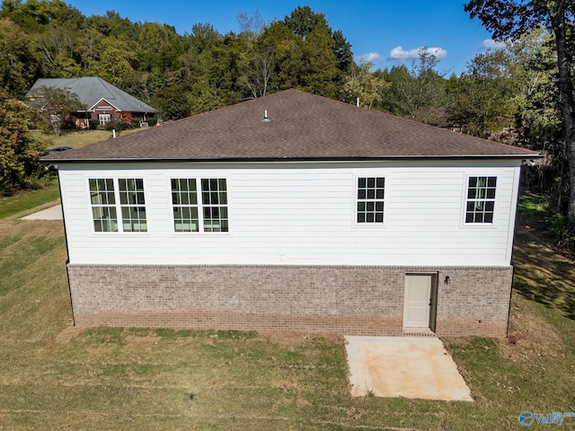 view of property exterior with a patio and a lawn