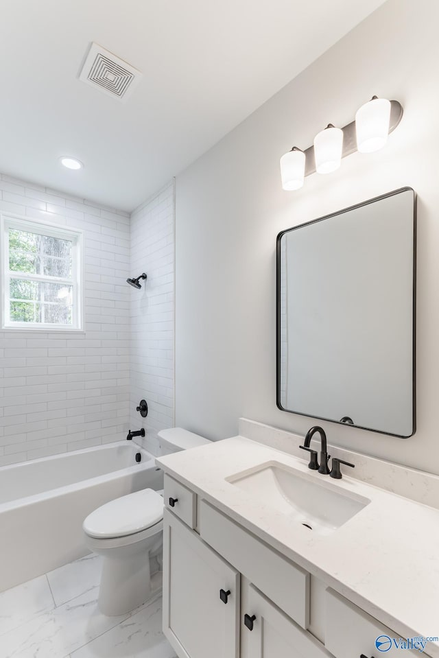 full bathroom featuring toilet, tiled shower / bath, and vanity