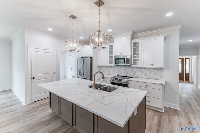 kitchen featuring white cabinets, a center island with sink, hanging light fixtures, appliances with stainless steel finishes, and sink