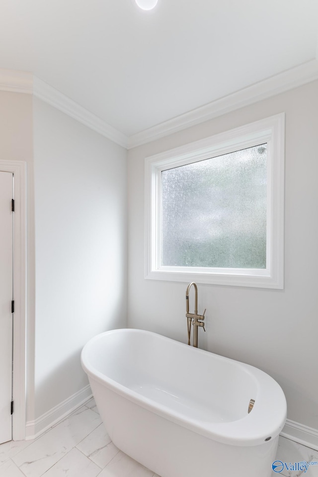 bathroom featuring ornamental molding and a tub to relax in