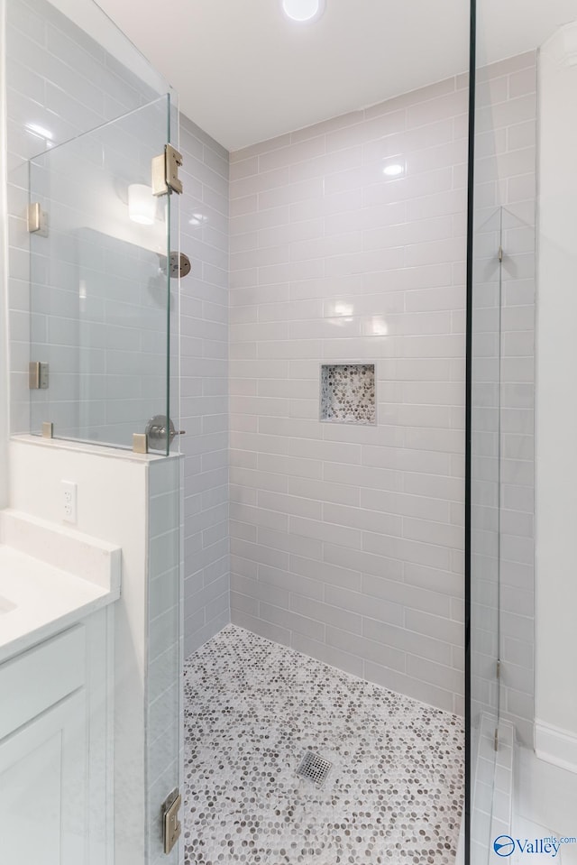 bathroom with vanity and a tile shower