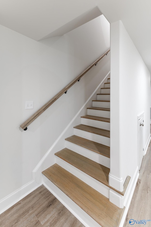 stairs featuring hardwood / wood-style floors