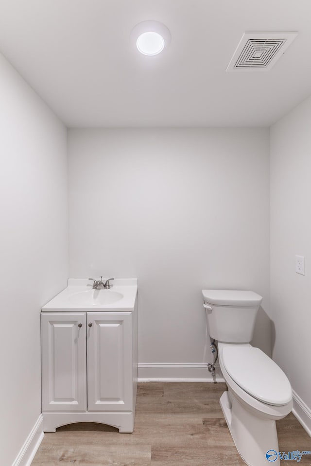 bathroom featuring vanity, hardwood / wood-style floors, and toilet