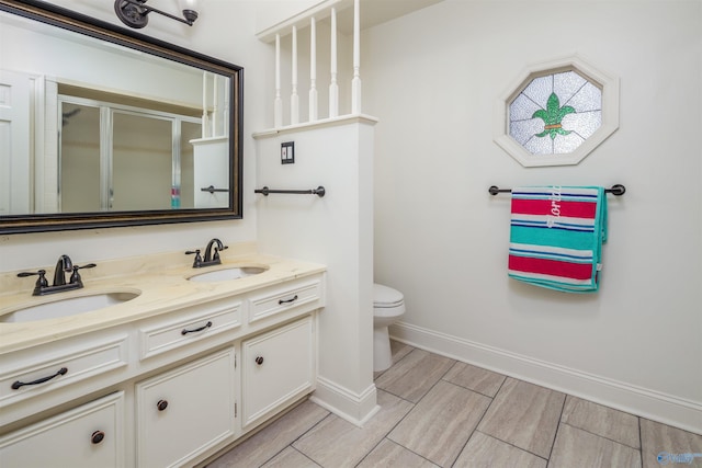 full bath with a sink, toilet, double vanity, and a shower stall