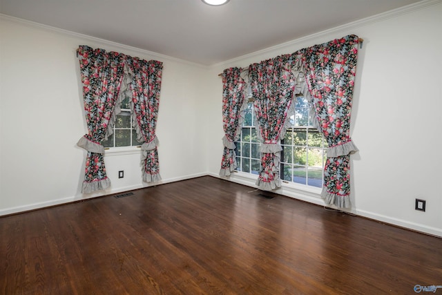 spare room featuring visible vents, wood finished floors, baseboards, and ornamental molding