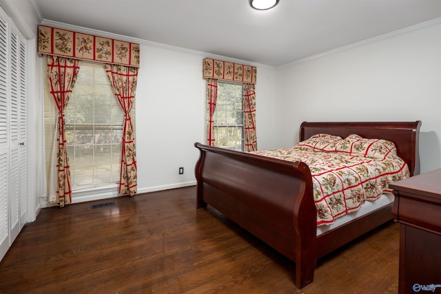 bedroom with visible vents, wood finished floors, baseboards, and ornamental molding