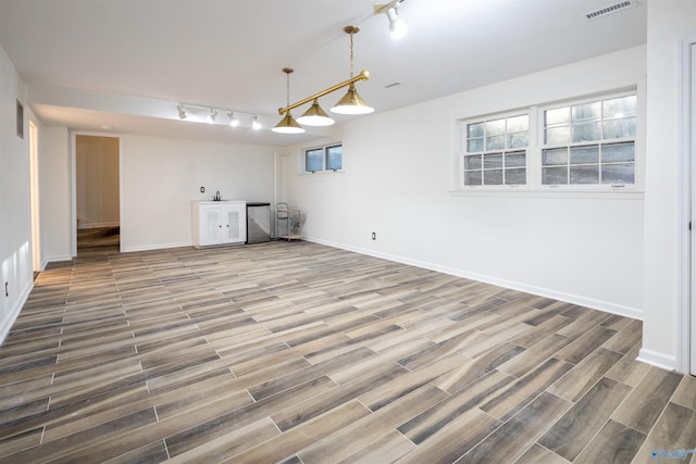 interior space with visible vents, baseboards, track lighting, and wood tiled floor