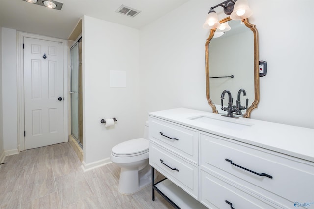 bathroom featuring vanity, baseboards, visible vents, a shower stall, and toilet