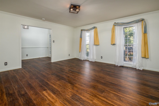 spare room featuring crown molding, wood finished floors, and baseboards