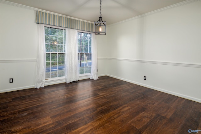 empty room with dark wood finished floors, a notable chandelier, baseboards, and ornamental molding