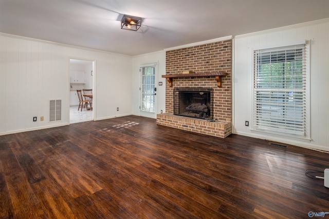 unfurnished living room featuring crown molding, wood finished floors, and visible vents