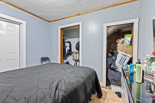 bedroom featuring light wood-type flooring and crown molding