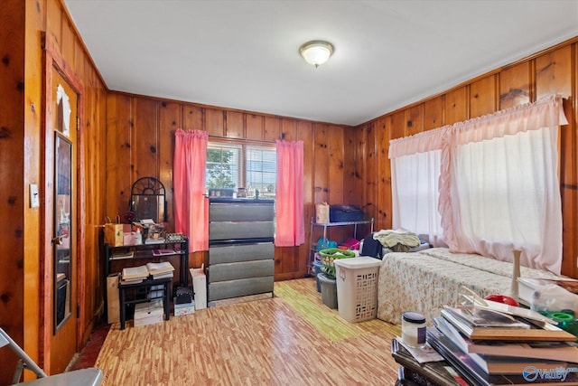 bedroom featuring wood finished floors and wooden walls