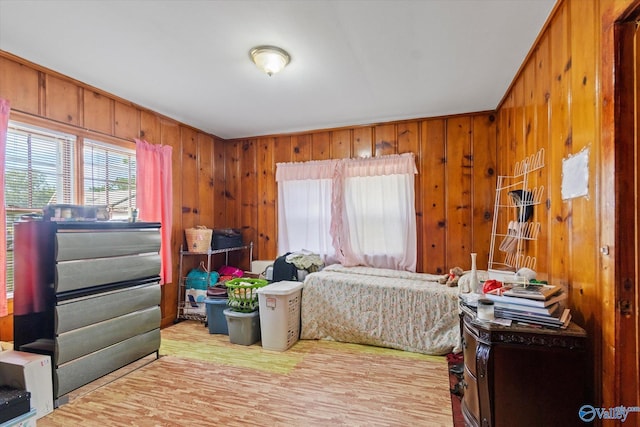 bedroom with wood walls and wood finished floors