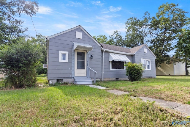 bungalow-style home with entry steps, crawl space, roof with shingles, and a front yard