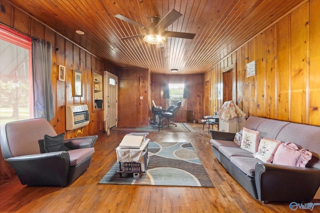 living room with wooden ceiling, ceiling fan, wood finished floors, heating unit, and wood walls