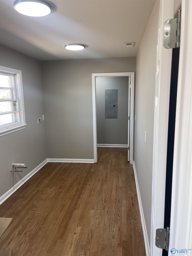 interior space with electric panel, visible vents, baseboards, and dark wood-style floors