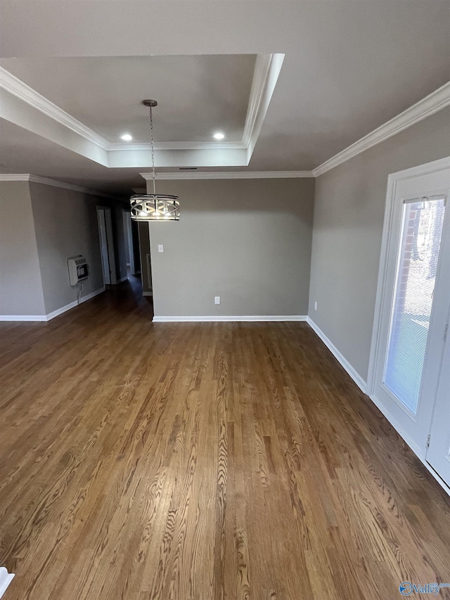 unfurnished dining area with baseboards, a raised ceiling, ornamental molding, and dark wood-style flooring